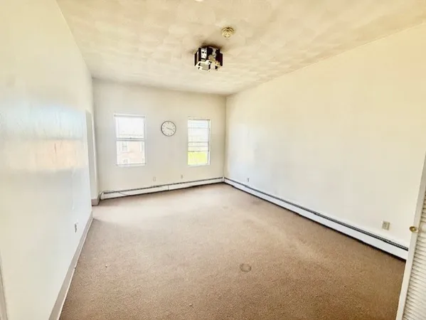 an empty room with windows and painted walls