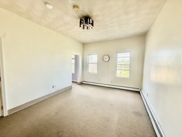 an empty room with windows and cabinet