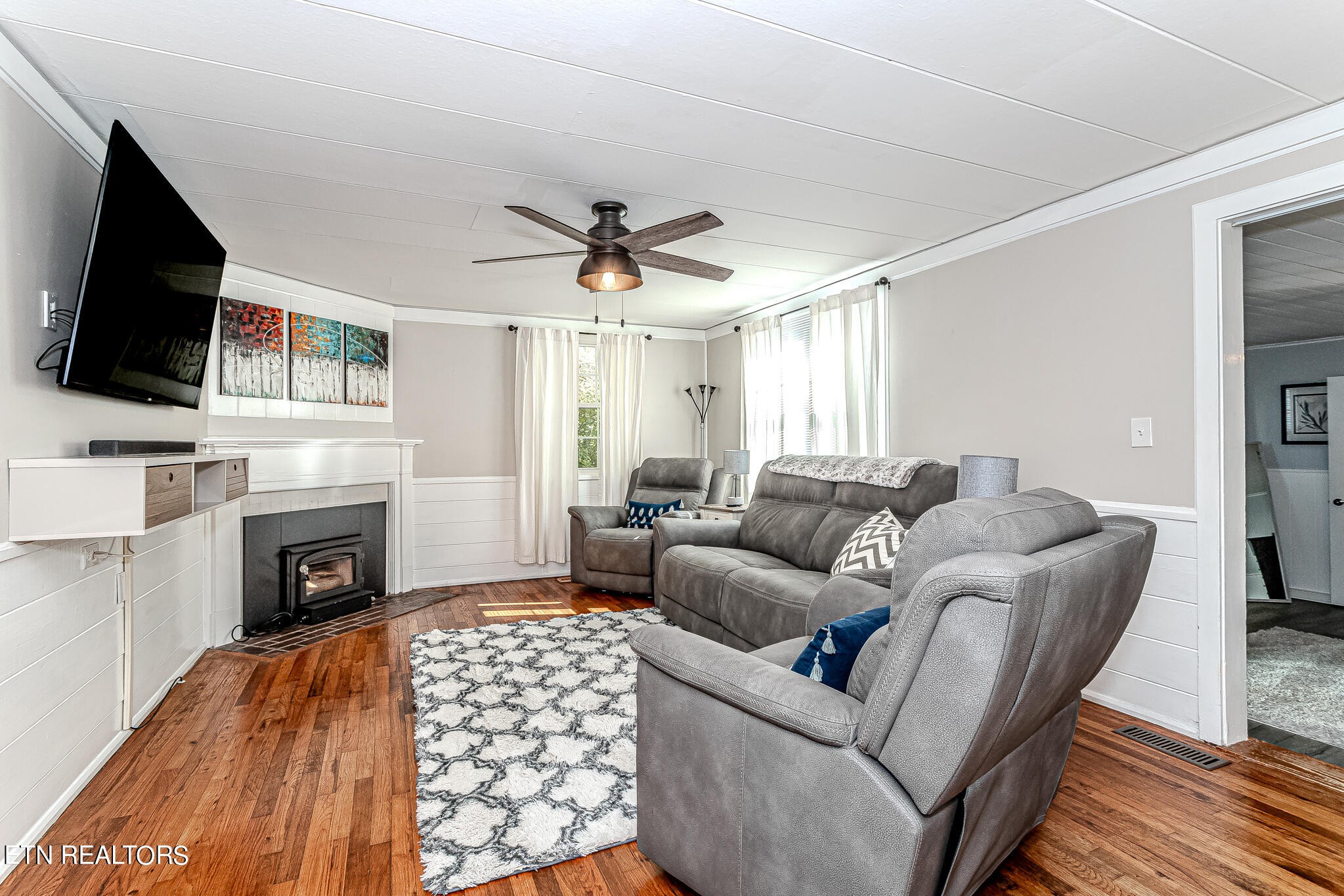 91 Orchard Road Norris, TN 37828 - Photo 20 of 54 a living room with furniture a fireplace and a flat screen tv