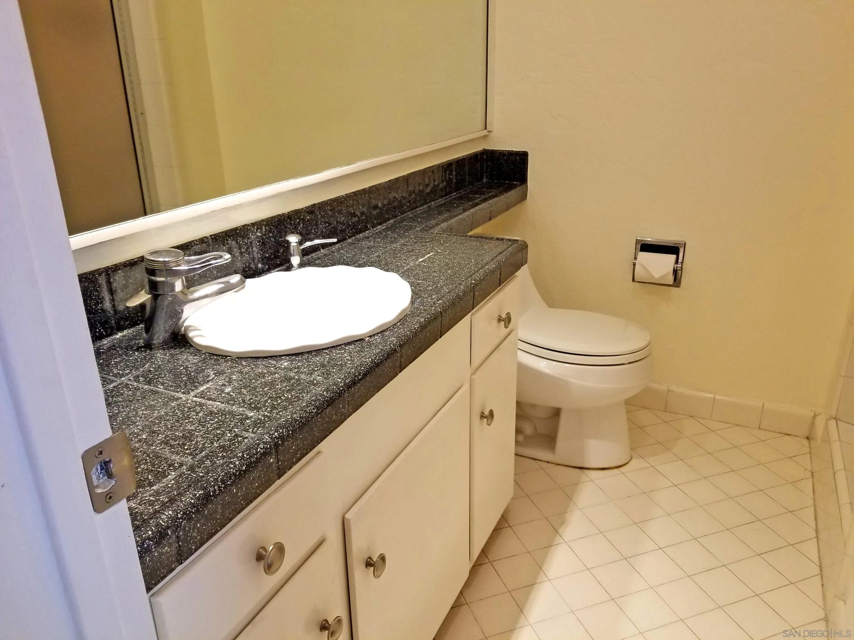 2358 Torrey Pines Road, Unit 19 La Jolla, CA 92037 - Photo 11 of 28 a bathroom with a granite countertop sink and a mirror
