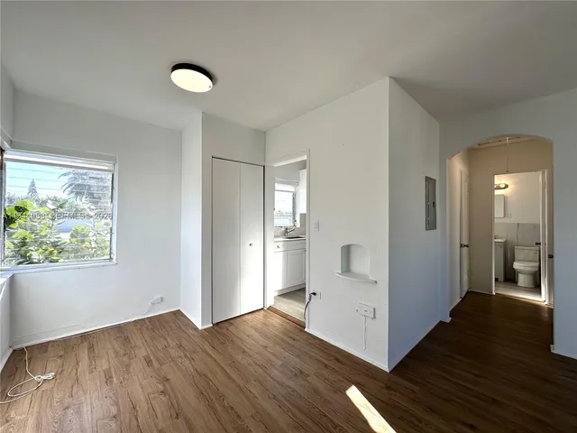 a view of a hallway with wooden floor and cabinet