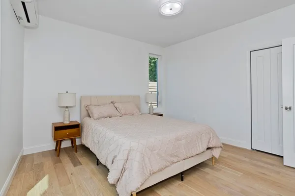 a bedroom with a bed and wooden floor