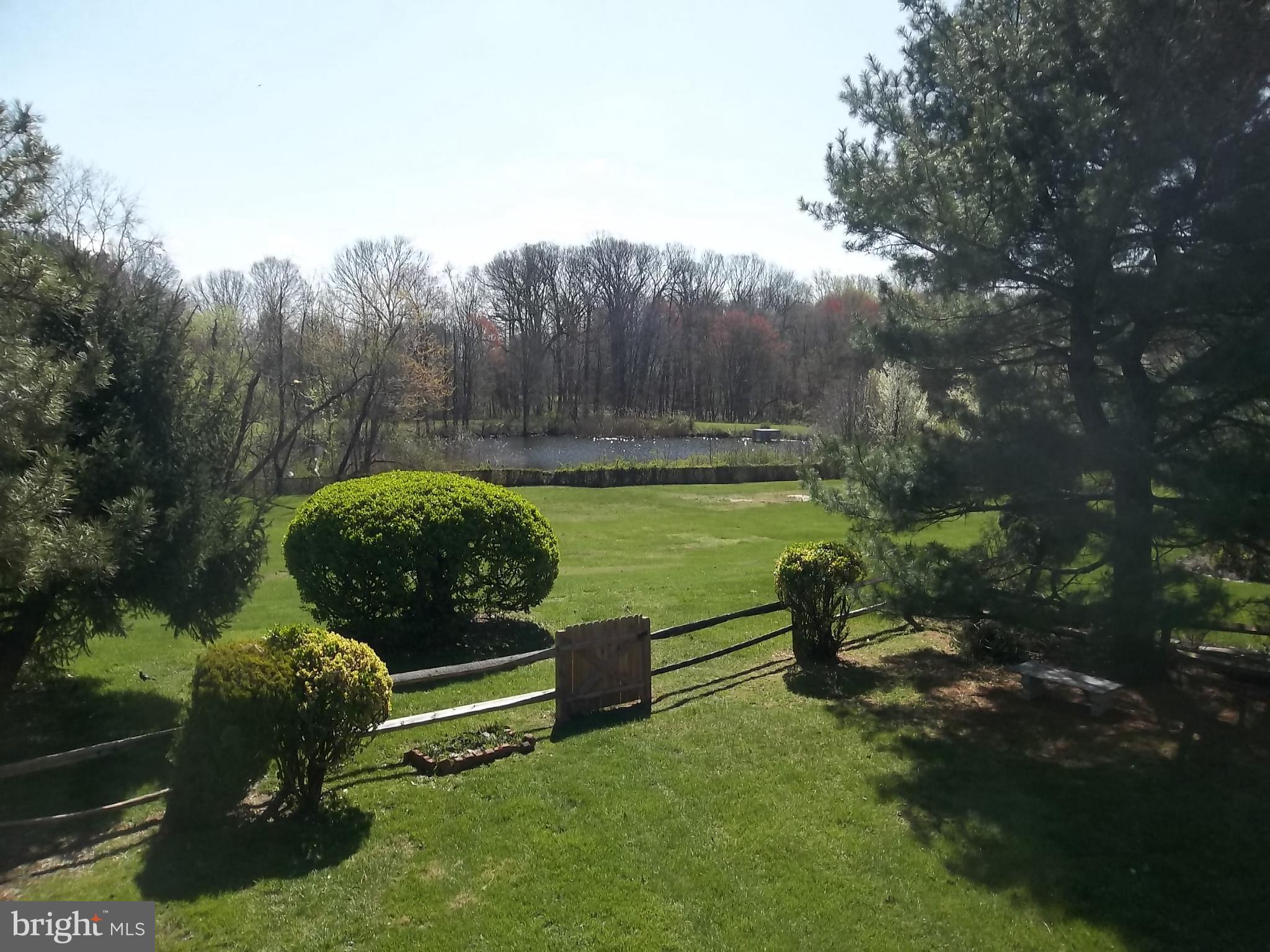 9107 Bowline Road Baltimore, MD 21236 - Photo 17 of 19 a view of a garden with a bench in a lake