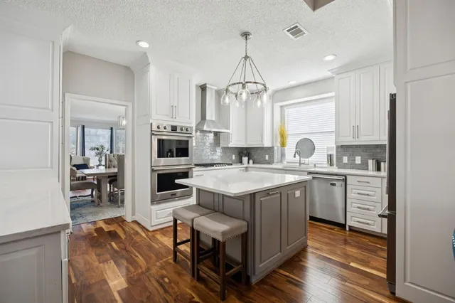a kitchen with stainless steel appliances a refrigerator a sink and a stove