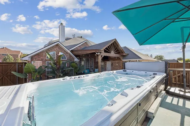 a roof deck with a yard and table under an umbrella