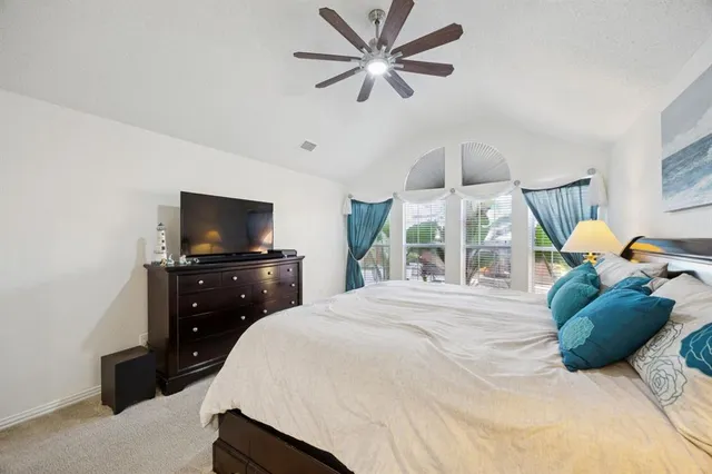 a spacious bedroom with a bed and a chandelier