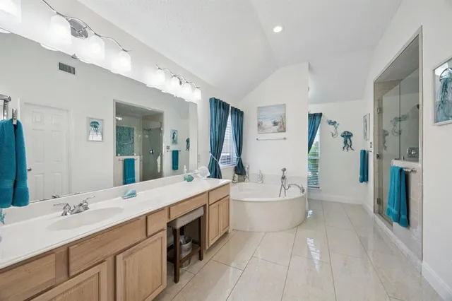a large bathroom with a double vanity sink mirror and bathtub