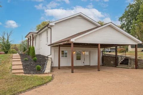a yellow house with trees in front of it