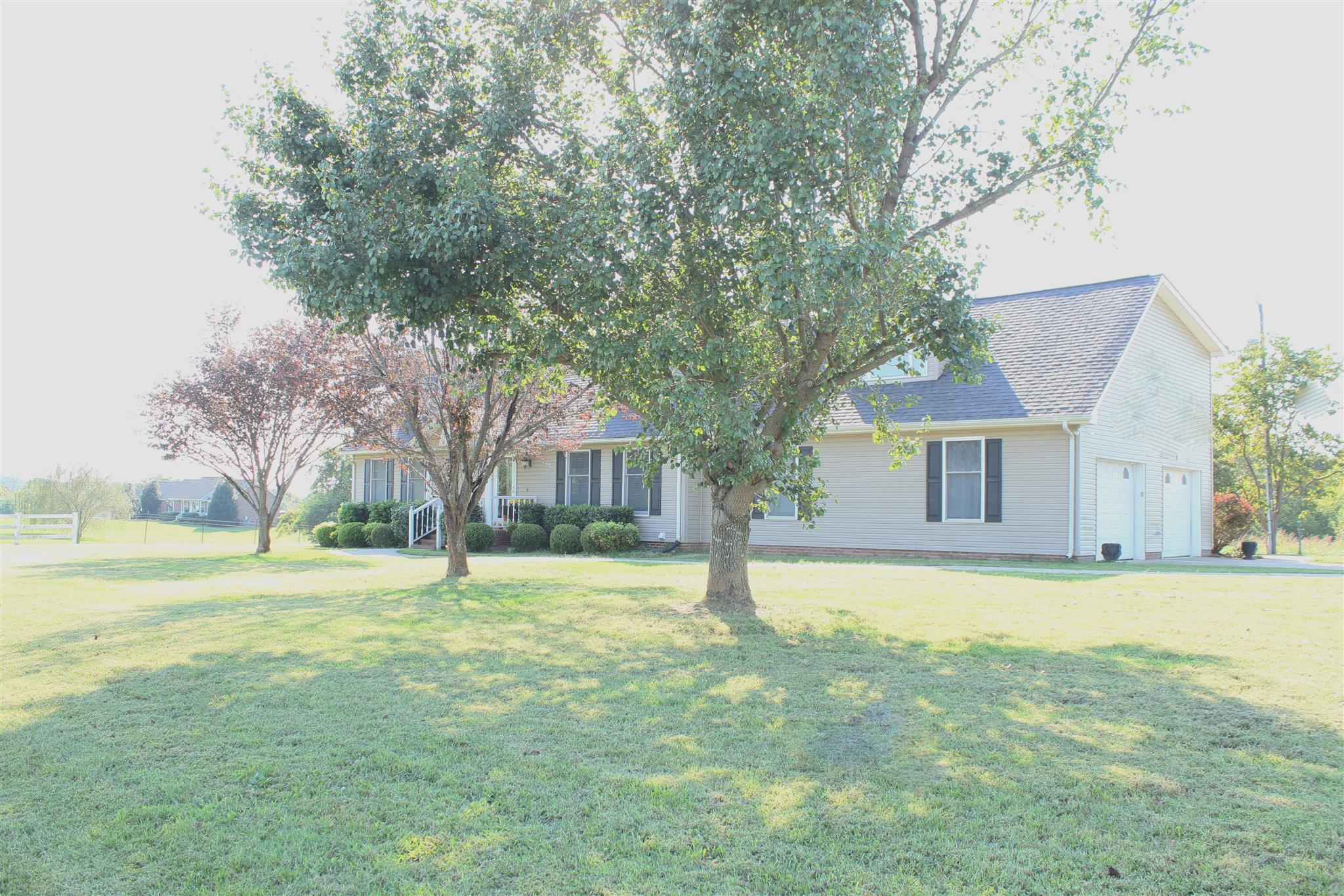 a view of a house with a yard and a tree