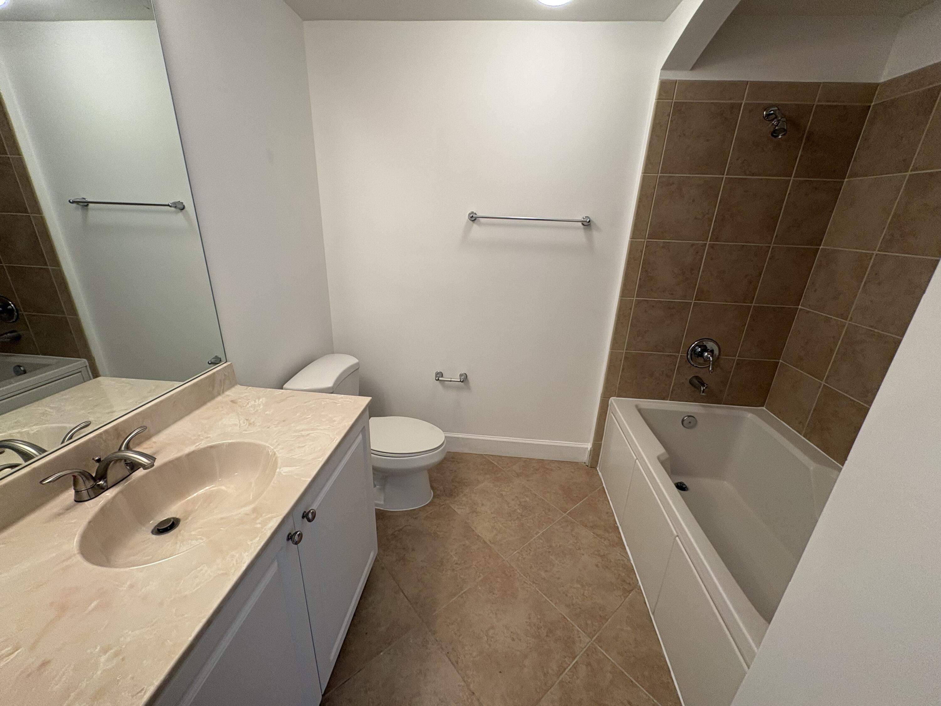 1420 Renaissance Way, Unit 420 Boynton Beach, FL 33426 - Photo 20 of 28 a bathroom with a sink and mirror with toilet