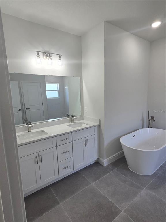 2644 Southwest 162nd Street Road Ocala, FL 34473 - Photo 24 of 47 a spacious bathroom with double vanity sink a mirror and a