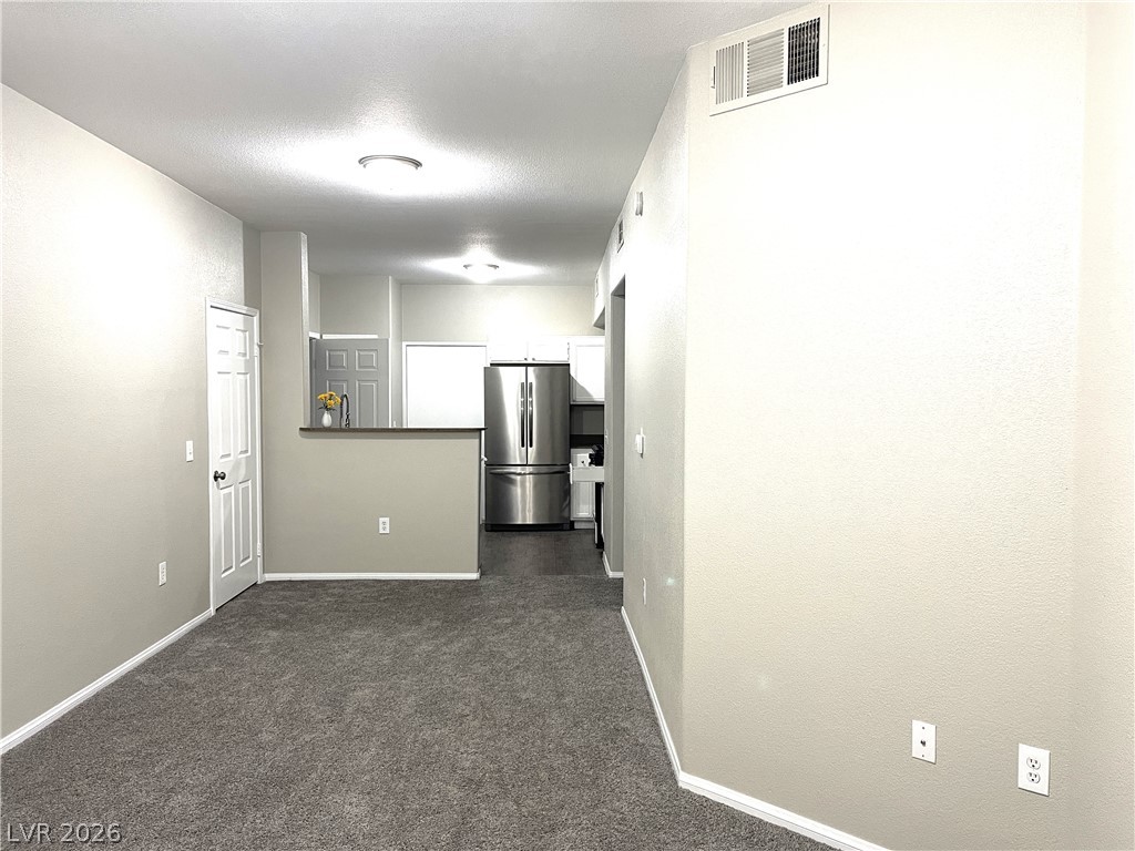 10001 Peace Way, Unit 1327 Las Vegas, NV 89147 - Photo 21 of 21 An open floor plan with plush carpet seamlessly connects to the modern kitchen.