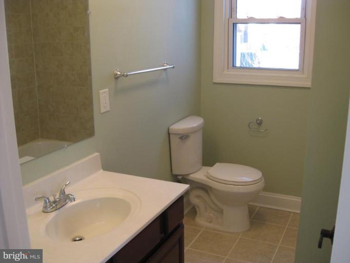 1220 Hilldale Road Rosedale, MD 21237 - Photo 18 of 19 a bathroom with a sink a toilet and a mirror