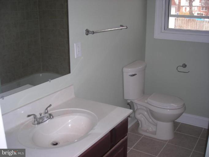 1220 Hilldale Road Rosedale, MD 21237 - Photo 10 of 19 a bathroom with a sink a toilet and mirror