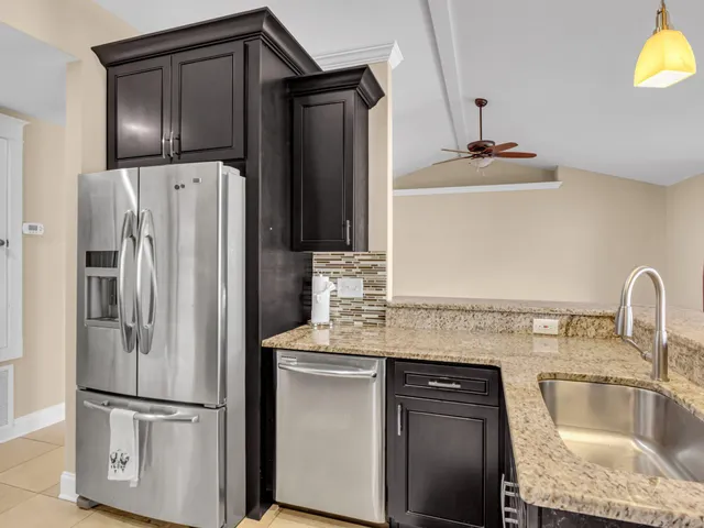 an empty room with windows and chandelier fan