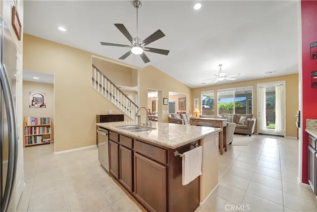 a dining hall with stainless steel appliances granite countertop a kitchen island a stove a sink a dining table and chairs