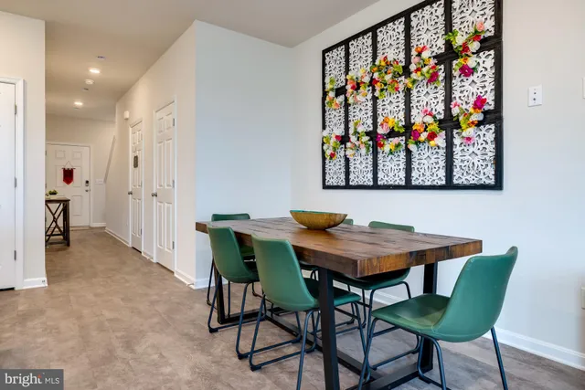a living room with furniture kitchen view and a wooden floor