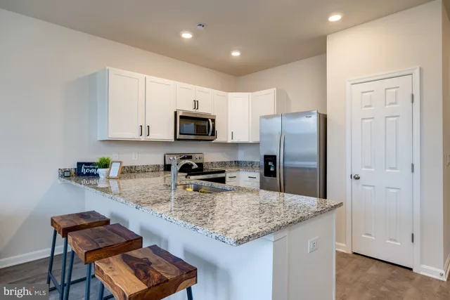 a kitchen with stainless steel appliances granite countertop a refrigerator stove and microwave