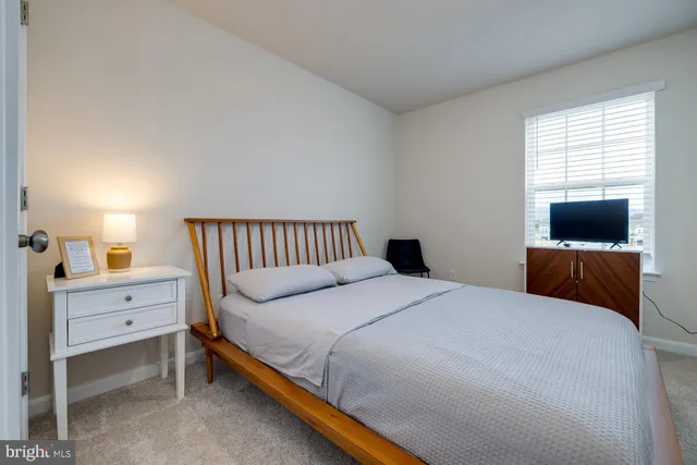 a bedroom with a bed chair and window