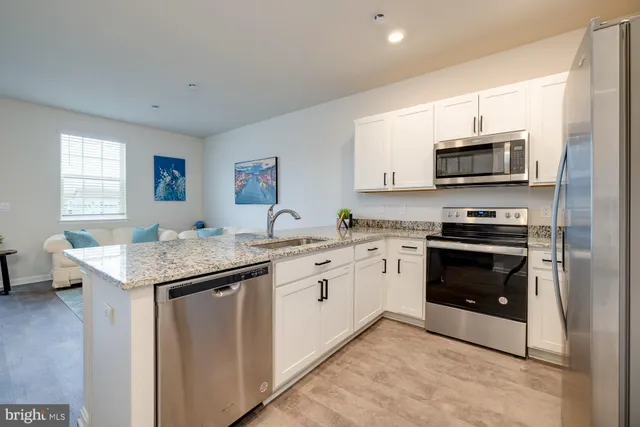 a kitchen with stainless steel appliances granite countertop a sink and cabinets