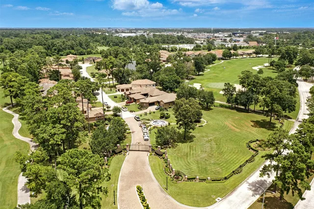 an aerial view of residential houses with outdoor space and trees