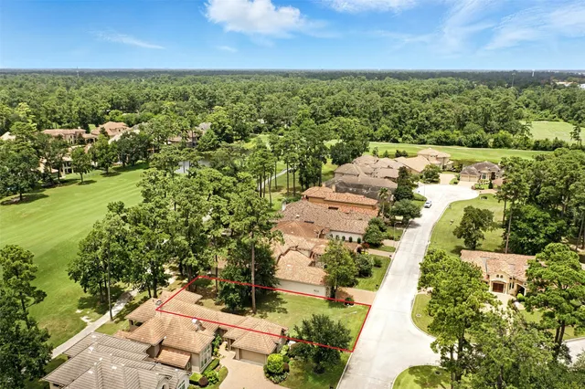 an aerial view of residential houses with outdoor space and trees