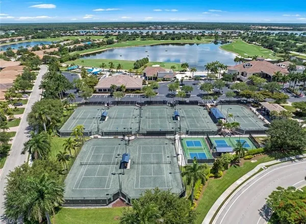 an aerial view of a tennis ground with a small yard and large trees