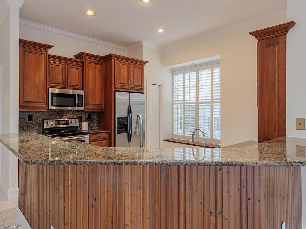 963 Fountain Run Naples, FL 34119 - Photo 4 of 12 a kitchen with stainless steel appliances granite countertop a refrigerator a stove top oven and a sink