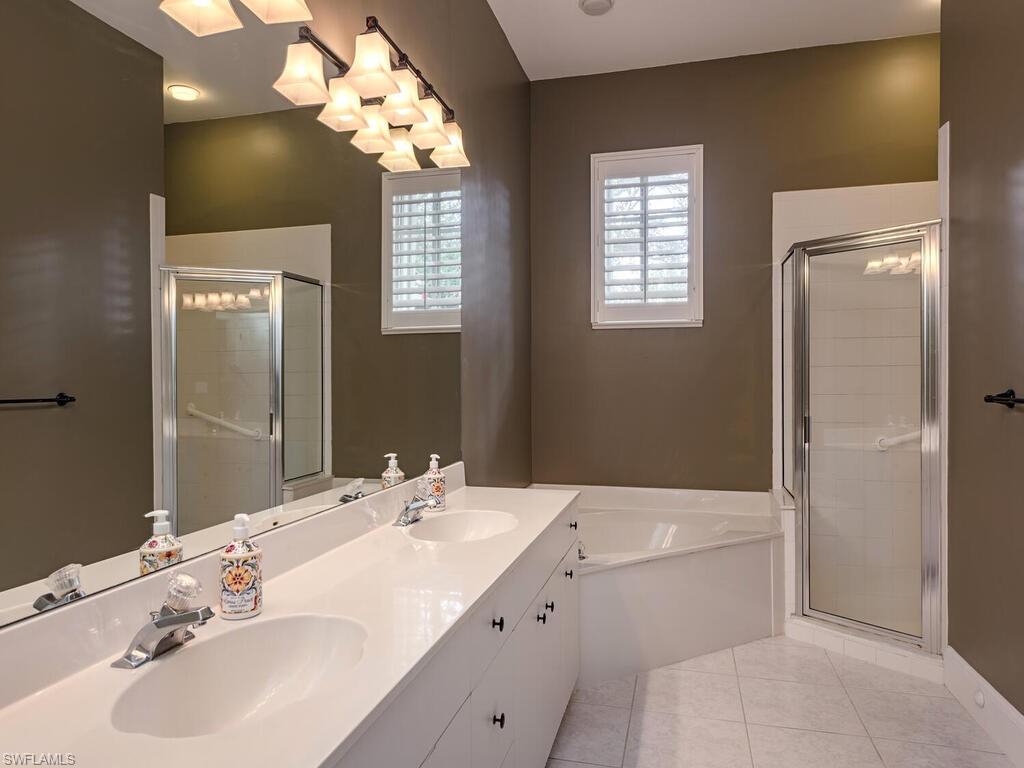963 Fountain Run Naples, FL 34119 - Photo 7 of 12 a bathroom with a sink a toilet and a mirror