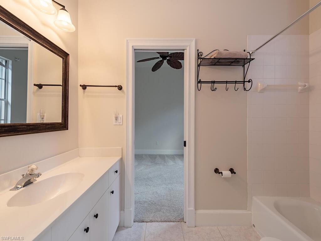 963 Fountain Run Naples, FL 34119 - Photo 9 of 12 a bathroom with a shower sink and mirror