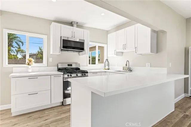 a kitchen with stainless steel appliances a stove microwave and sink
