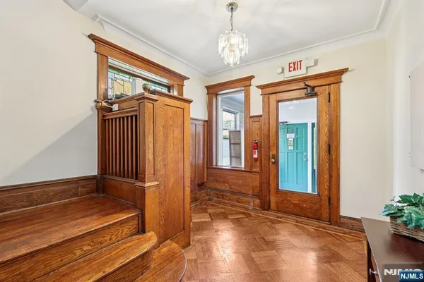 a view of a hallway with wooden floor and stairs