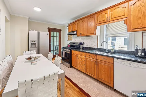 a kitchen with stainless steel appliances kitchen island granite countertop a sink and cabinets