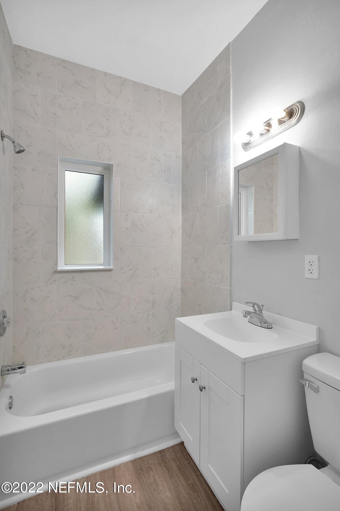 6715 Morgana Road North Jacksonville, FL 32211 - Photo 19 of 27 a bathroom with a toilet a sink a mirror and bathtub