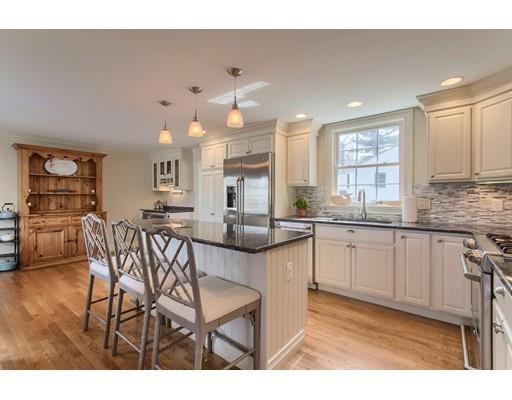 24 Paul Revere Road Needham, MA 02494 - Photo 10 of 30 a kitchen with stainless steel appliances kitchen island granite countertop a table chairs sink and cabinets