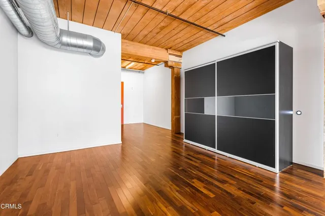 a view of an empty room with wooden floor