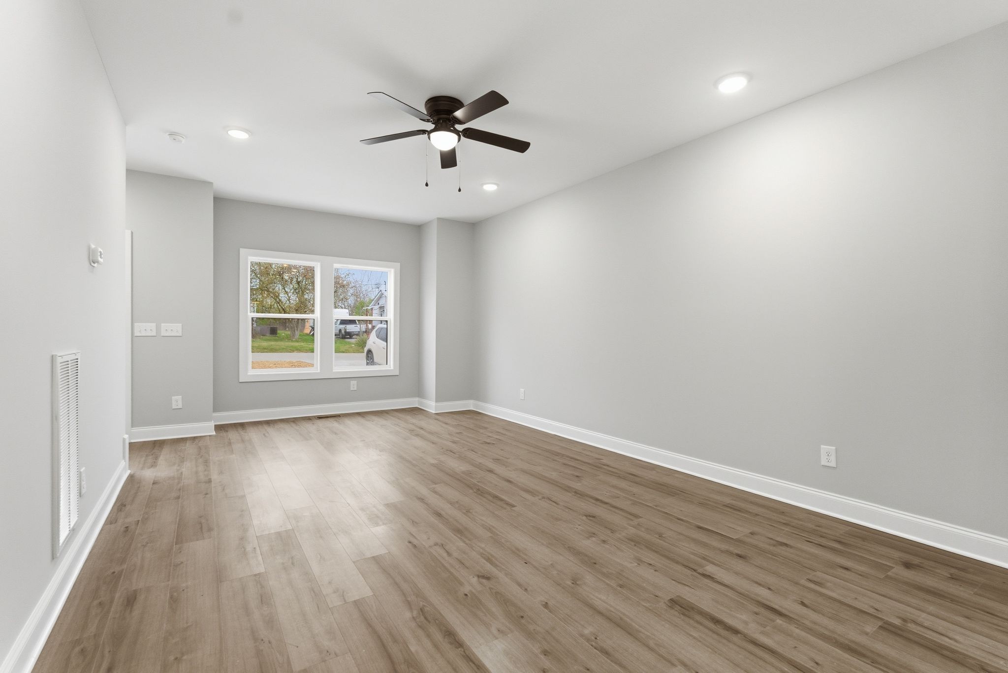 263 West Spring Street Smithville, TN 37166 - Photo 7 of 23 an empty room with wooden floor chandelier fan and windows