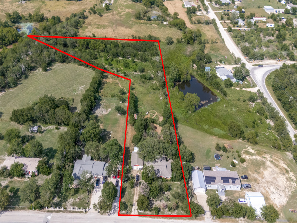 1035 Palomino Road Kyle, TX 78640 - Photo 2 of 13 Overhead view reveals a sizable lot with lush greenery and tranquil pond access.
