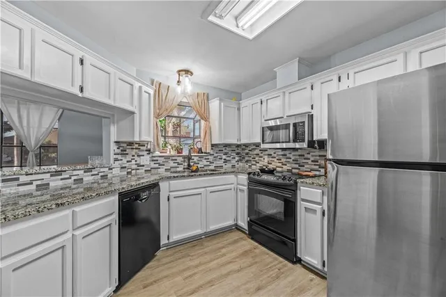 a kitchen with stainless steel appliances granite countertop a refrigerator sink and stove