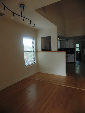 a view of a big room with wooden floor and windows