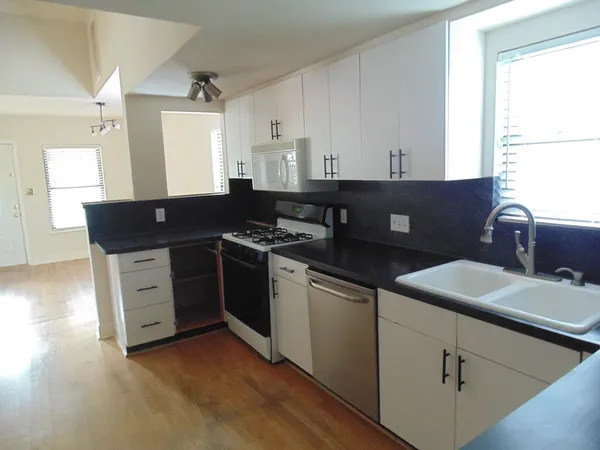 a kitchen with stainless steel appliances granite countertop a sink stove and cabinets