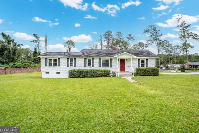 a front view of a house with a garden