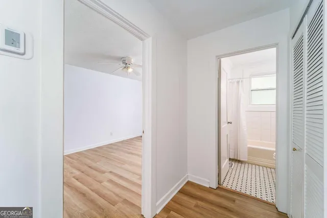 a view of a room with wooden floor and a ceiling fan