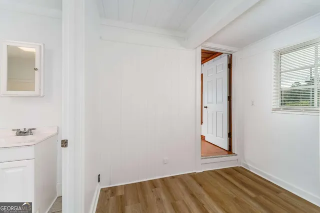 a view of a bathroom with a sink cabinet and a window