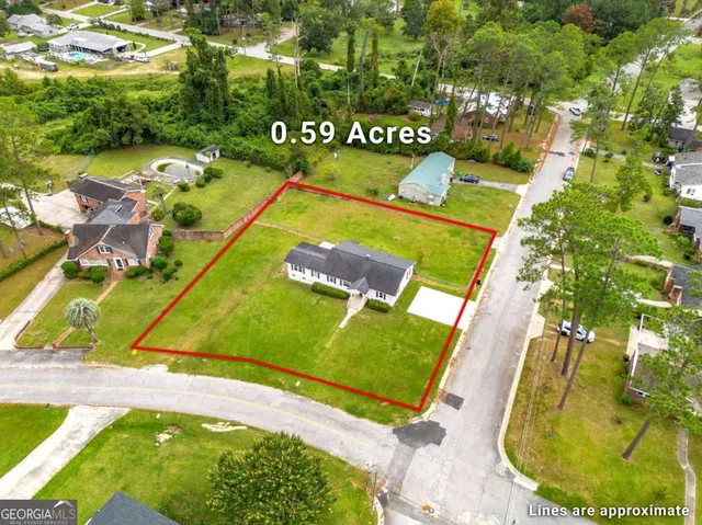 an aerial view of residential houses with outdoor space and trees
