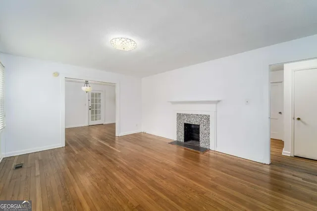 a view of empty room with wooden floor and fireplace
