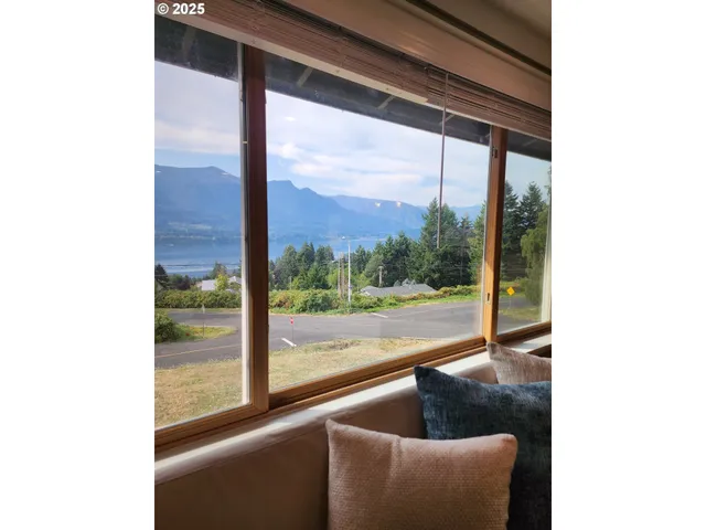 a view of a room with a large window and front of door
