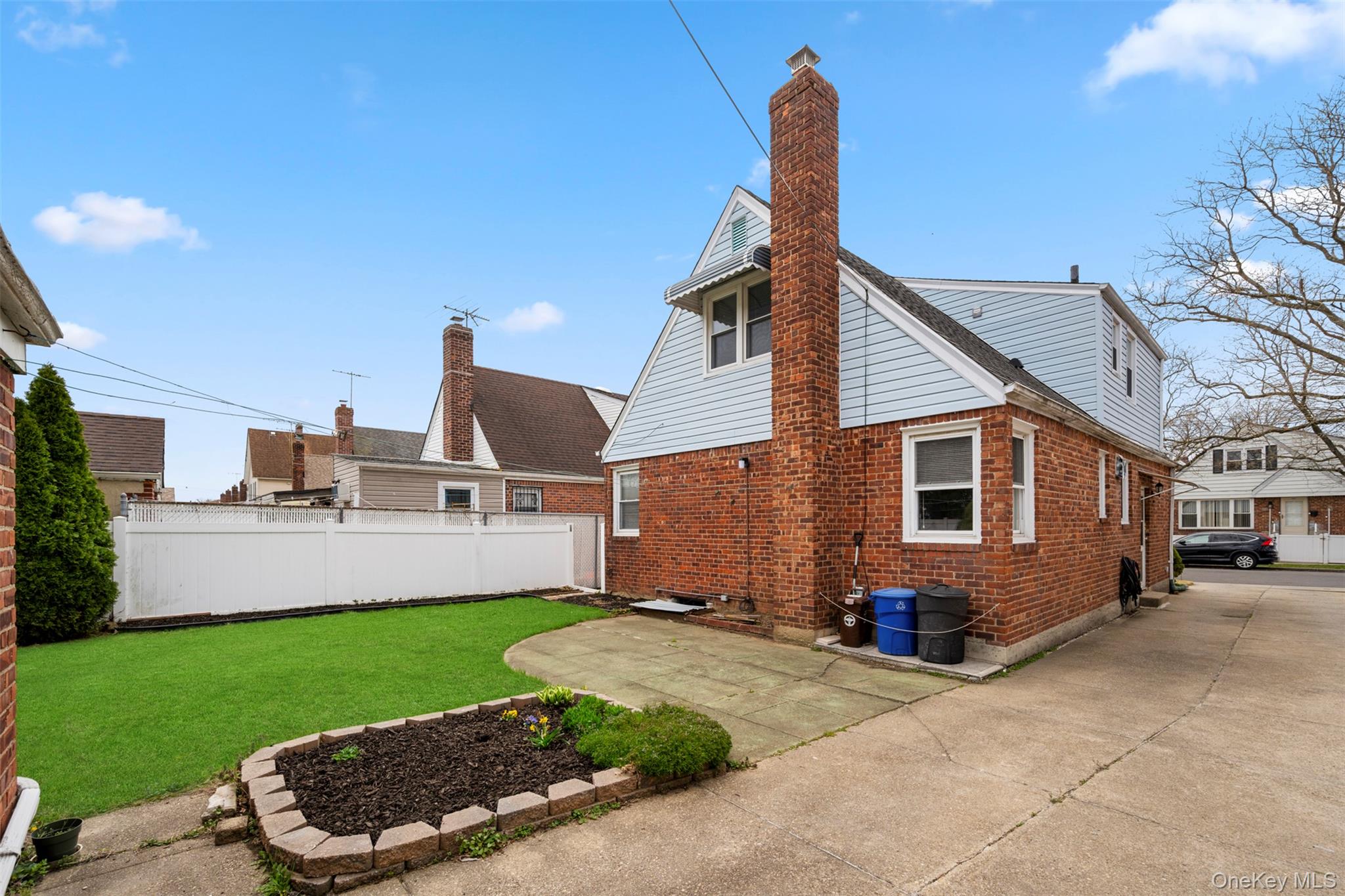 8807 Sabre Street Queens, NY 11427 - Photo 24 of 29 a front view of a house with a garden and yard