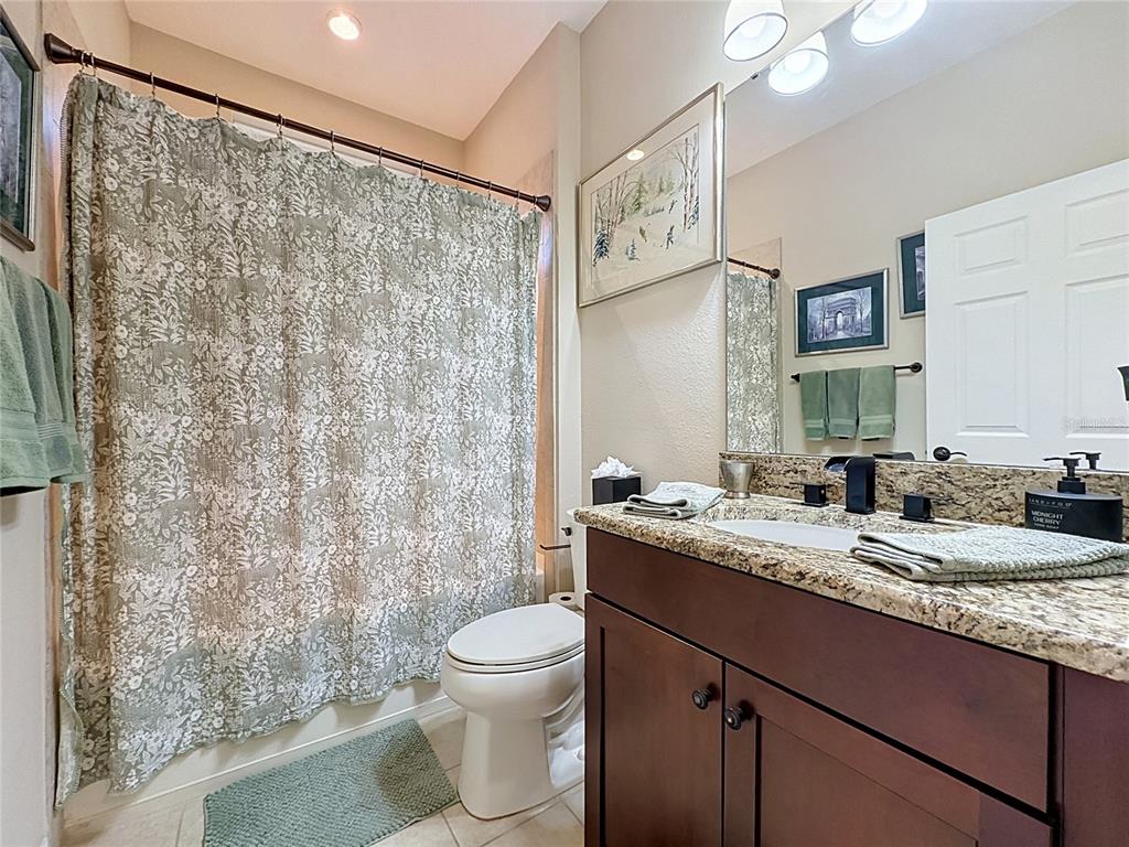 255 Silver Maple Road Groveland, FL 34736 - Photo 39 of 68 a bathroom with a granite countertop sink toilet and shower