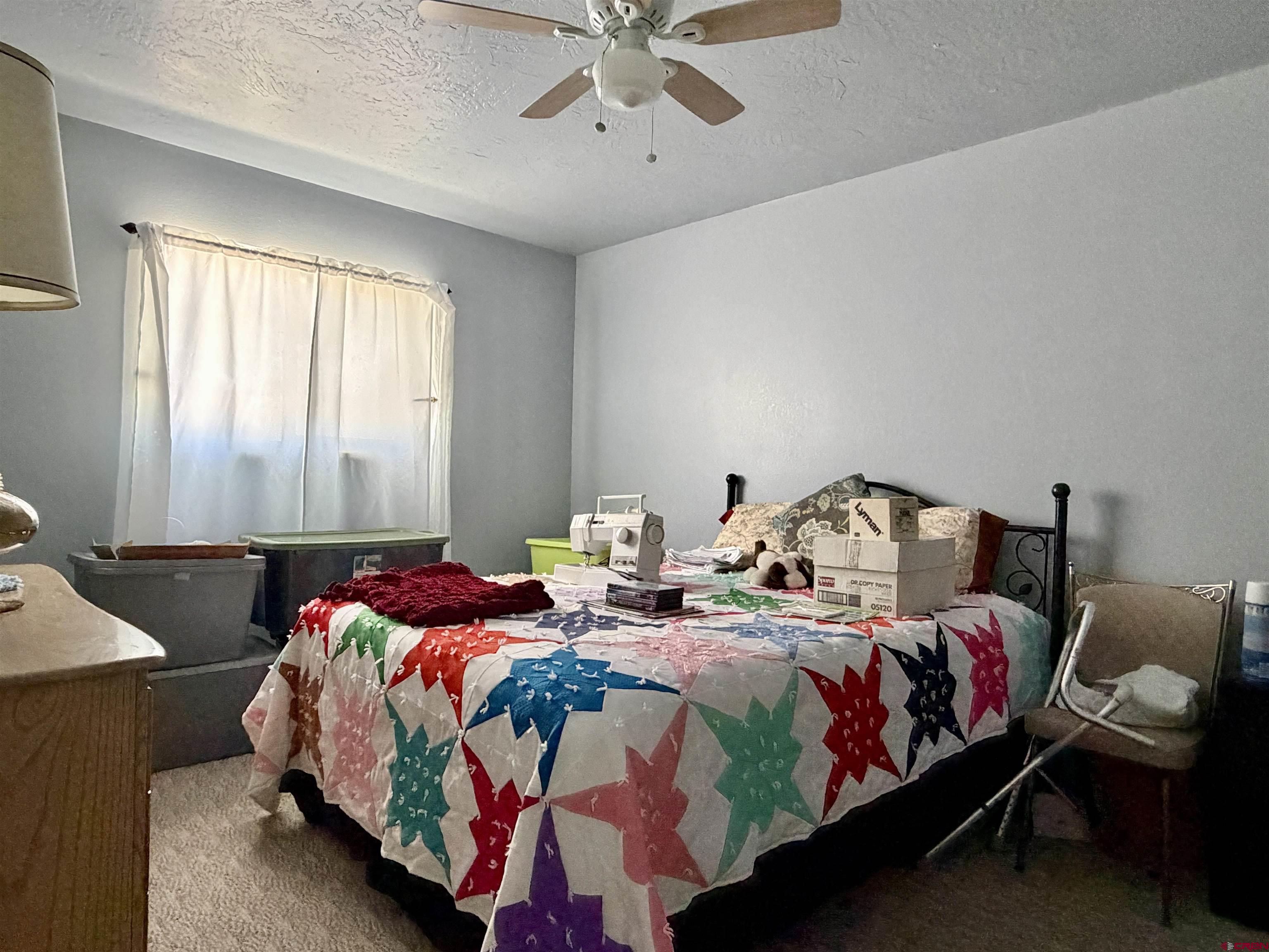 265 Northwest 10th Street Cedaredge, CO 81413 - Photo 25 of 40 a bedroom with two beds and a chandelier